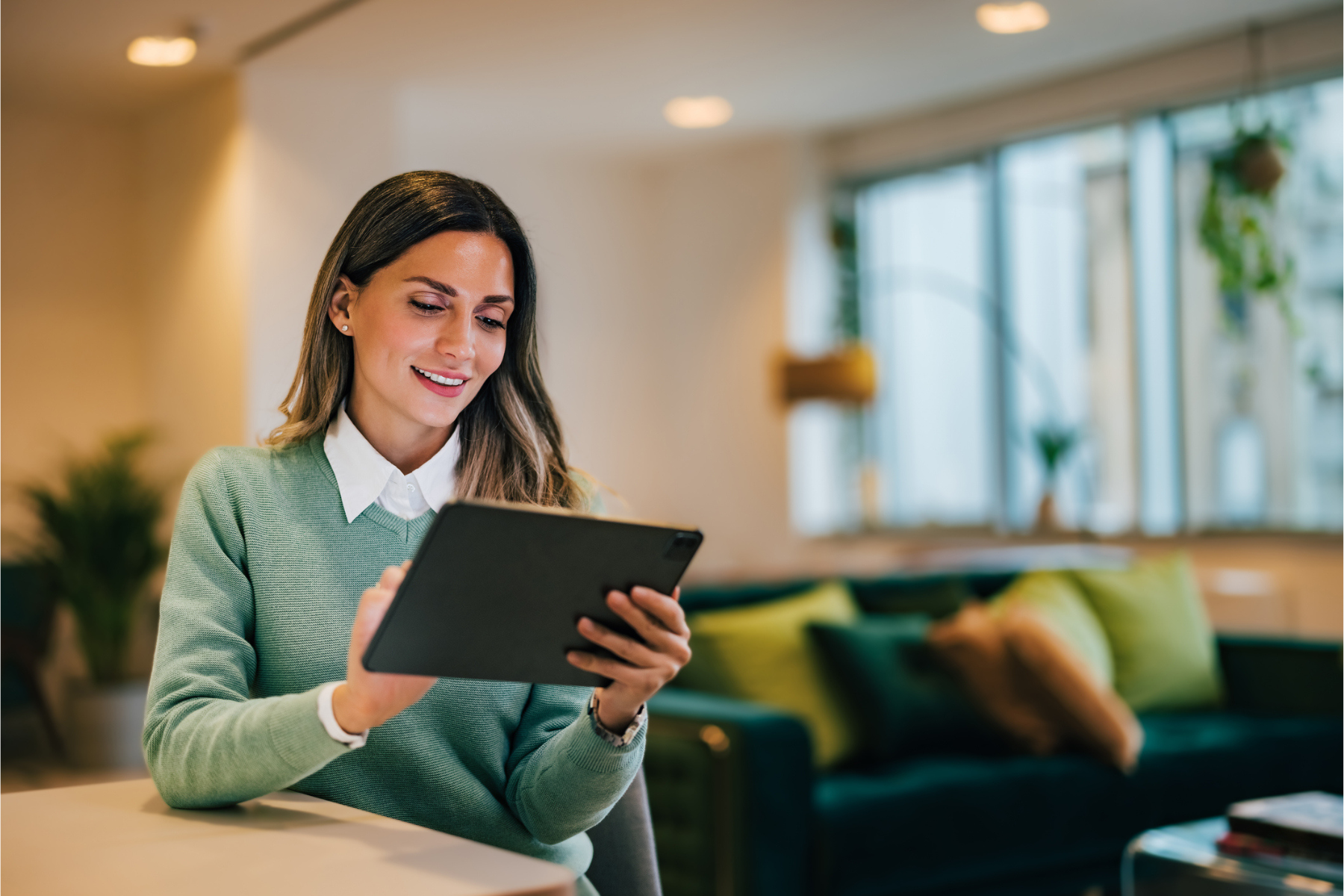 Mujer emprendedora con tablet revisando estrategias de negocio en una oficina moderna.