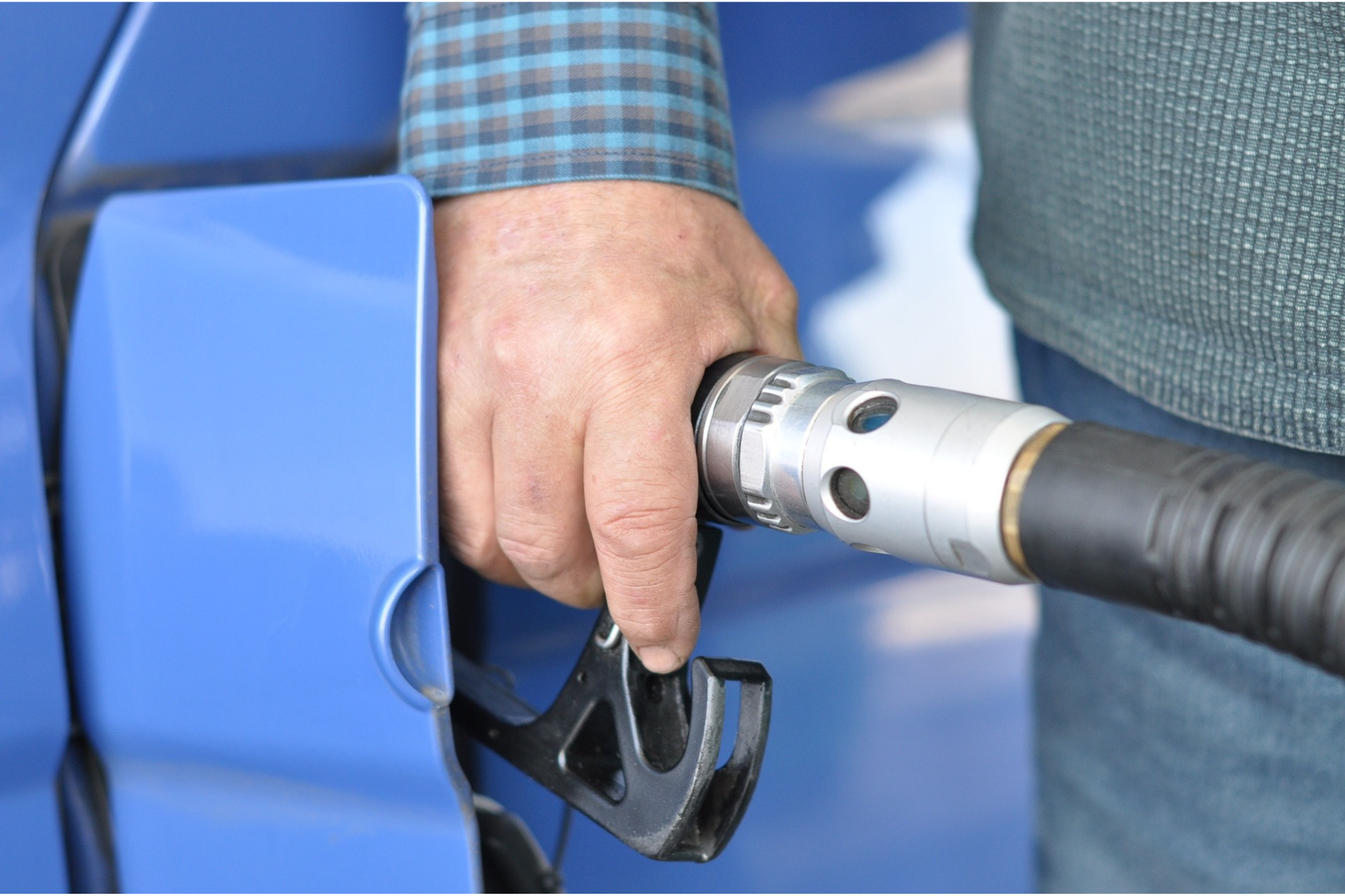 Hombre abasteciendo gasolina en una estación de servicio, representando el impacto de la actualización del IEPS en combustibles para 2025.