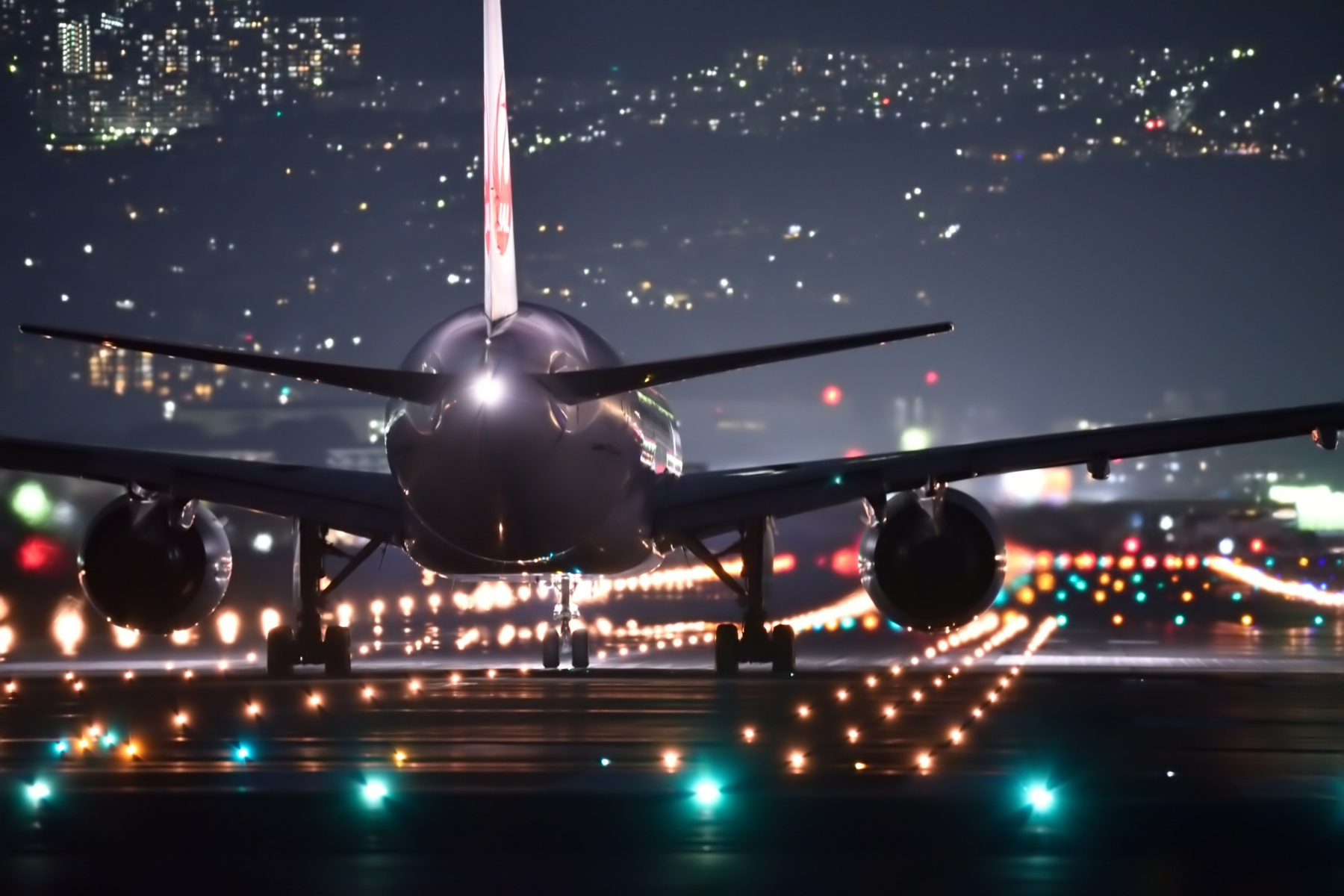 Punta de un avión en pista iluminada durante la noche, representando la expansión y modernización de los aeropuertos de Guadalajara y Puerto Vallarta.