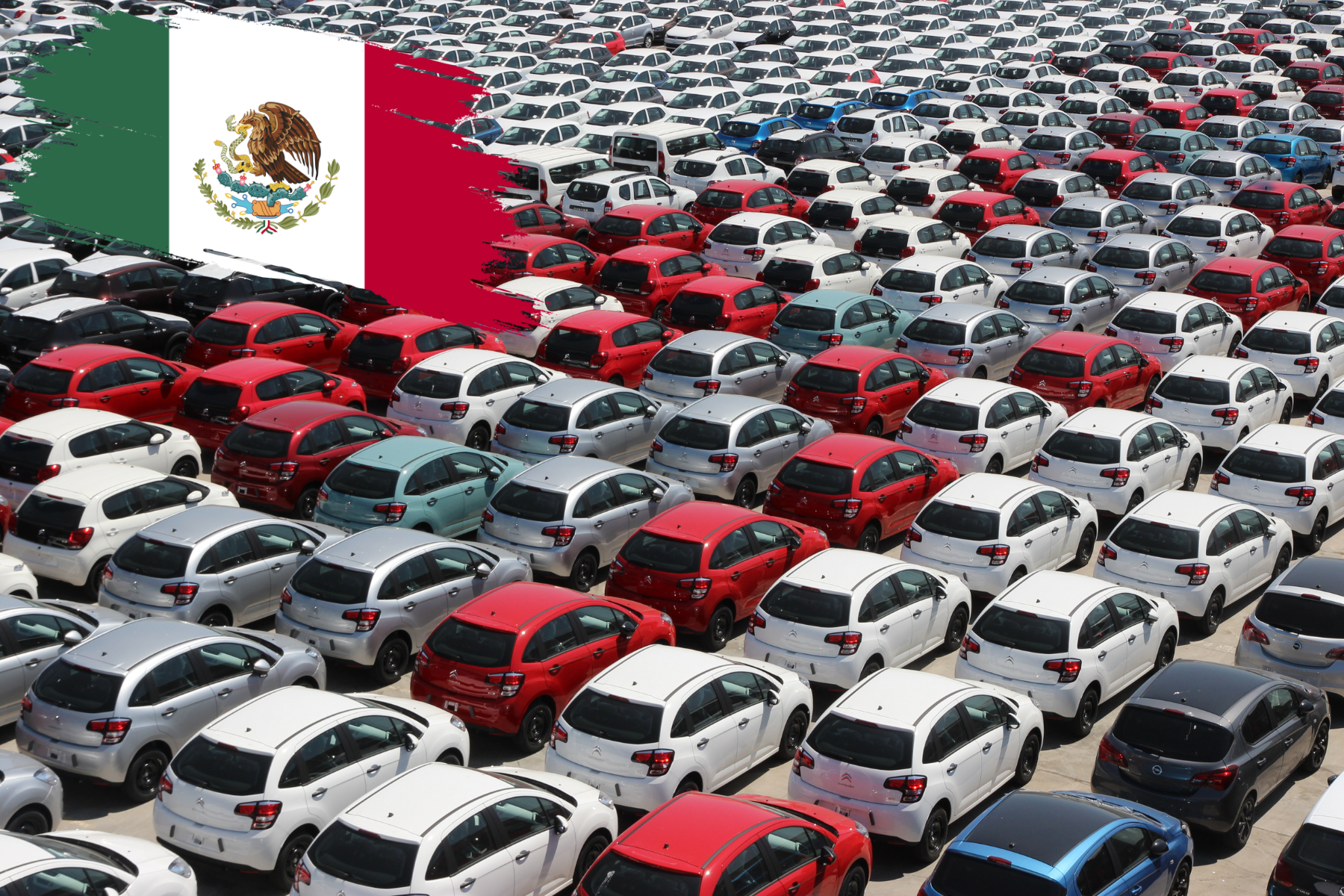 Vista panorámica de una planta automotriz con numerosos autos estacionados y una gran bandera de México al fondo, simbolizando la fortaleza del sector automotriz en el país.
