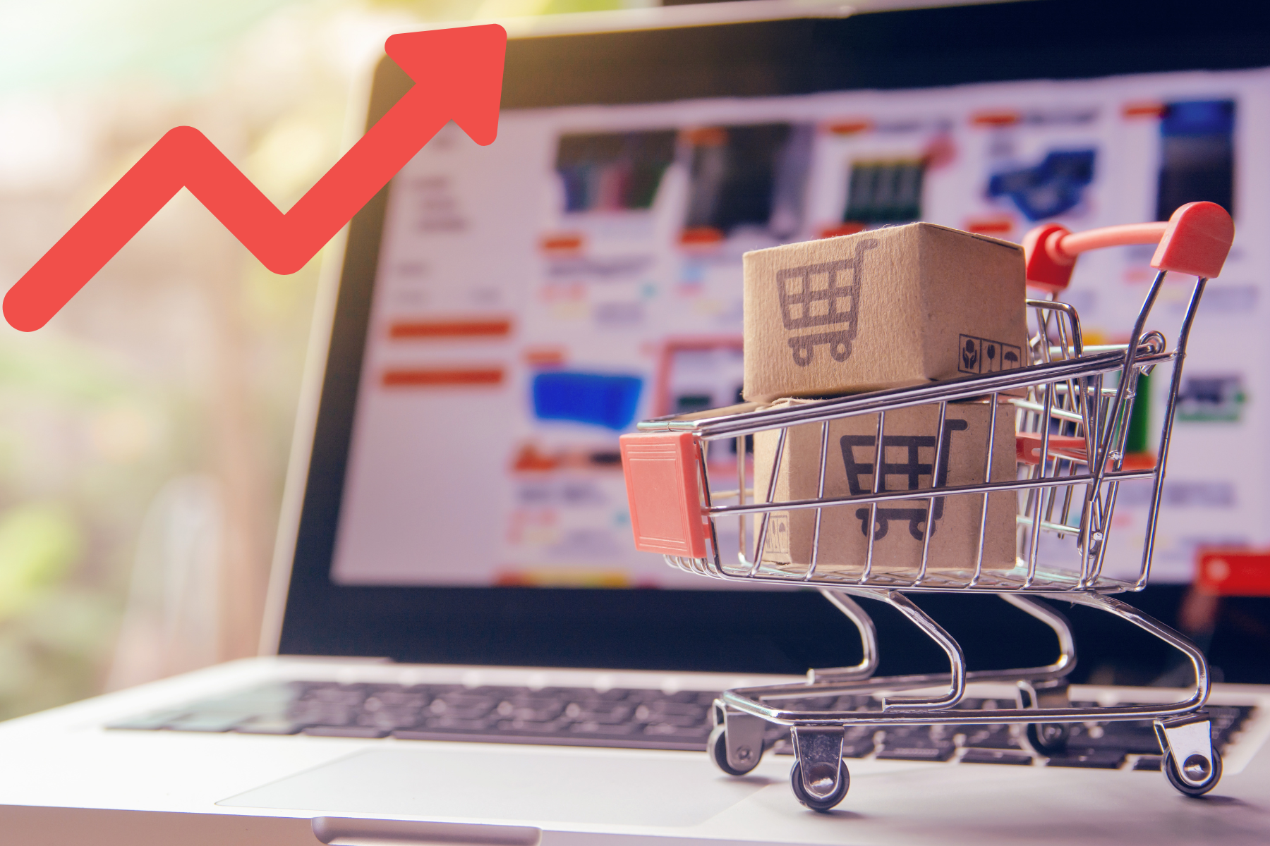 Carrito de compras frente a una computadora que muestra un gráfico de barras en ascenso, simbolizando el aumento en la recaudación por impuestos a compras en línea e importaciones.