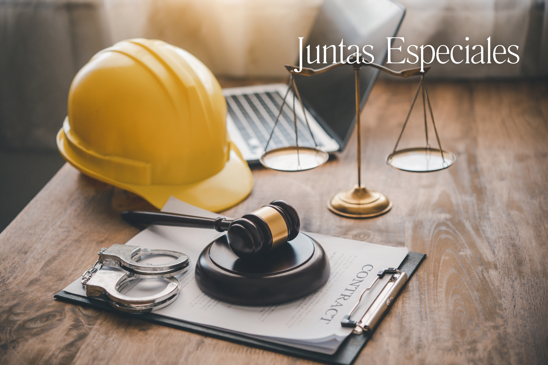 Casco de seguridad, balanza de la justicia, esposas, contrato laboral y martillo de juez sobre un escritorio, simbolizando la reestructuración de competencias en la justicia laboral.