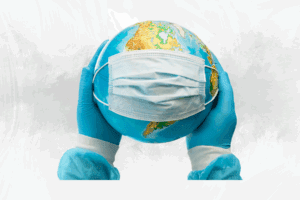 Manos humanas sostienen un globo terráqueo con un cubrebocas, representando la protección global y la cooperación sanitaria internacional