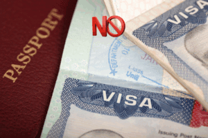 Imagen digital que muestra dos visas estadounidenses acompañadas de un letrero rojo con la palabra “NO”, simbolizando la prohibición de entrada a Estados Unidos.