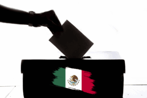 una urna en votaciones con la bandera de México.