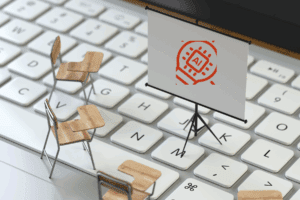 Imagen de un teclado frente a pupitres en un aula, con un pizarrón que muestra un símbolo de inteligencia artificial, representando la necesidad de formación en IA en el ámbito laboral de México.